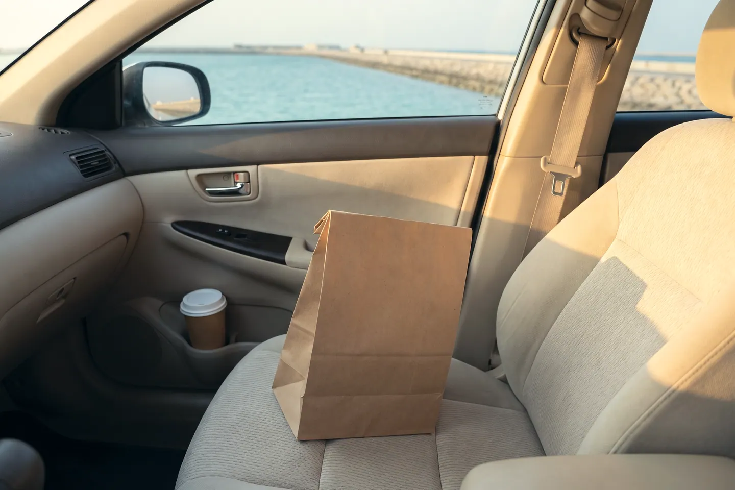 A takeaway bag handed from one pair of hands to another at a doorway