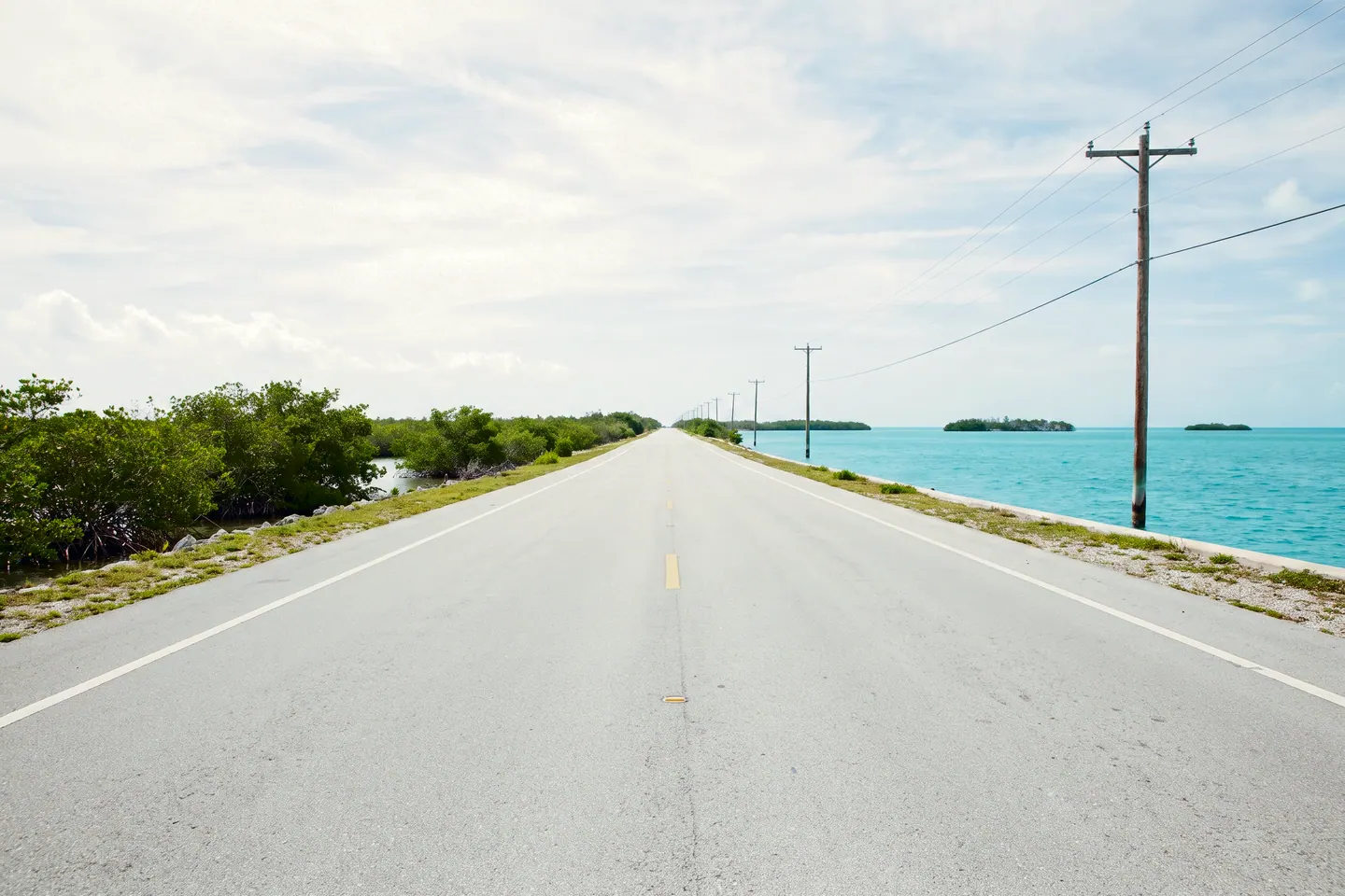 An empty island highway running to a vanishing point under a wide sky